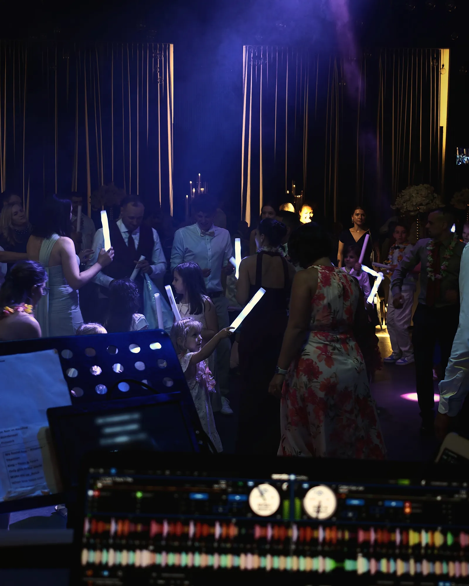 Blick vom DJ-Pult auf die Tanzfläche mit Leuchtstäben bei einer Hochzeit in Berlin